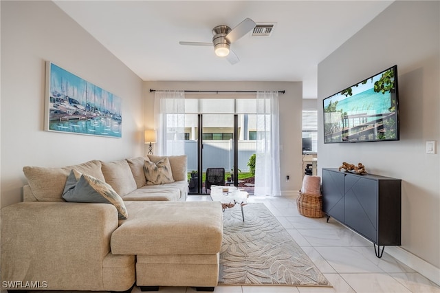 living area with a ceiling fan, visible vents, and baseboards