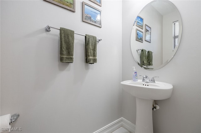 bathroom with a sink and baseboards