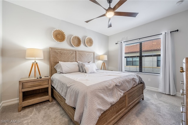 bedroom with baseboards, a ceiling fan, and light colored carpet