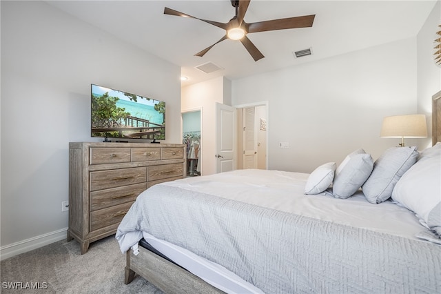 bedroom featuring light colored carpet, visible vents, baseboards, a walk in closet, and attic access