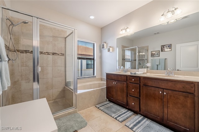 bathroom featuring tile patterned flooring, a sink, a shower stall, a bath, and double vanity