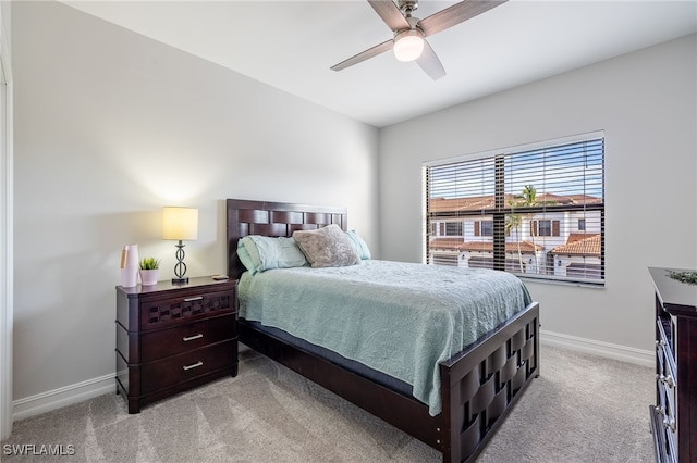 bedroom featuring light carpet, ceiling fan, and baseboards