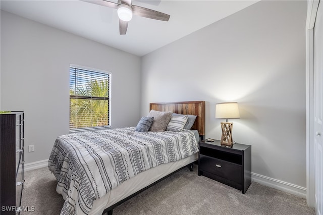 carpeted bedroom with ceiling fan and baseboards