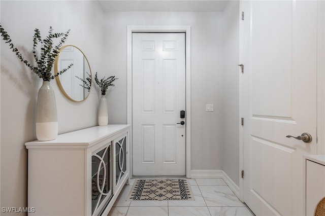 entryway featuring marble finish floor and baseboards