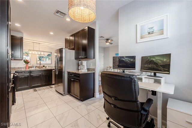 kitchen featuring freestanding refrigerator, marble finish floor, a sink, and dark brown cabinets