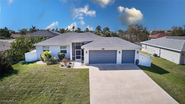 ranch-style home with a garage, fence, concrete driveway, stucco siding, and a front lawn