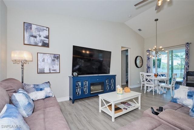 living area with lofted ceiling, wood finished floors, and baseboards