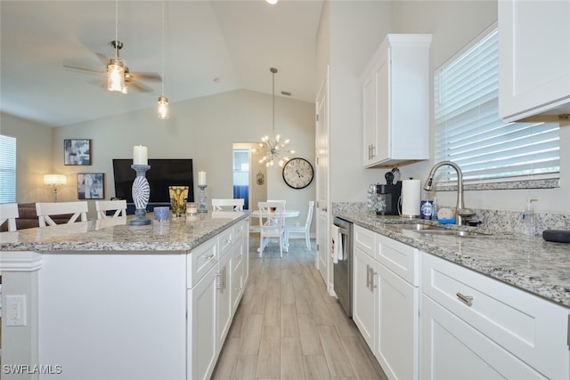 kitchen featuring dishwasher, a center island, vaulted ceiling, white cabinetry, and a sink