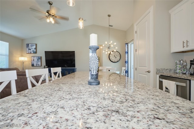 kitchen featuring light stone counters, pendant lighting, lofted ceiling, open floor plan, and white cabinetry