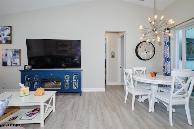 dining area with a chandelier, vaulted ceiling, baseboards, and wood finished floors