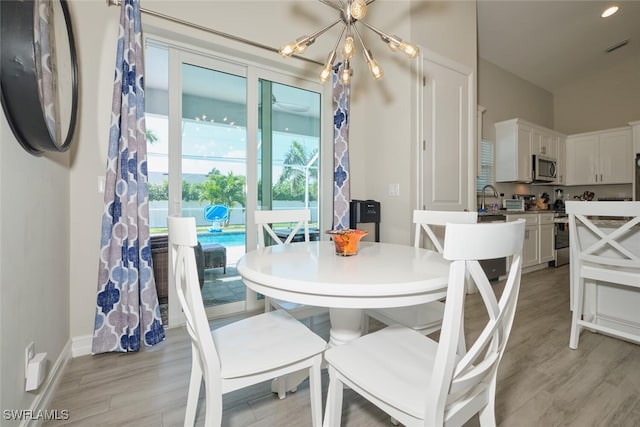 dining space with a chandelier, light wood finished floors, visible vents, and baseboards