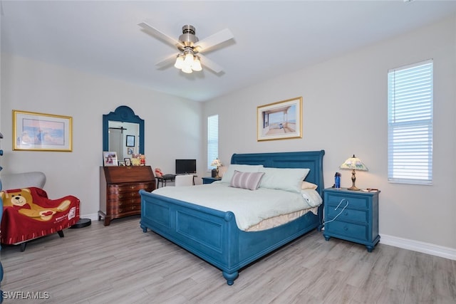 bedroom with light wood-style floors, ceiling fan, and baseboards