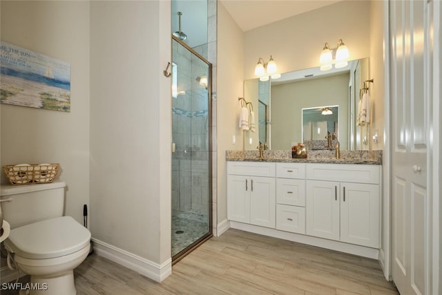 full bathroom featuring a sink, a stall shower, wood finished floors, and toilet