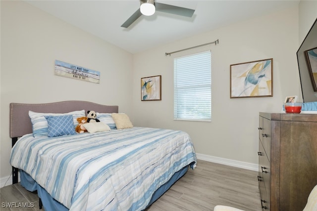 bedroom with ceiling fan, baseboards, and wood finished floors