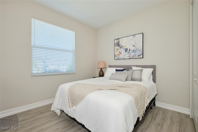 bedroom featuring light wood-type flooring and baseboards