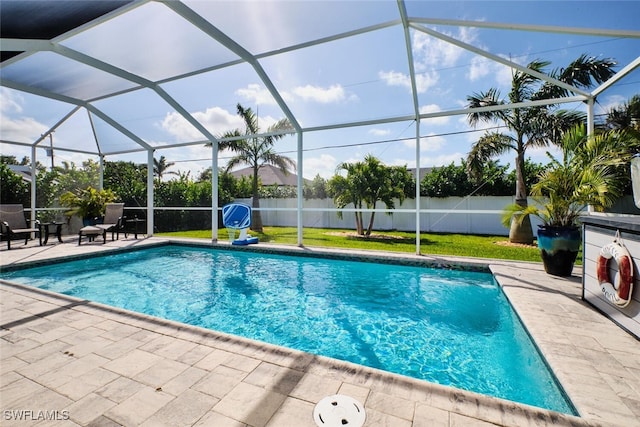 view of swimming pool with glass enclosure, a patio area, a fenced backyard, and a fenced in pool