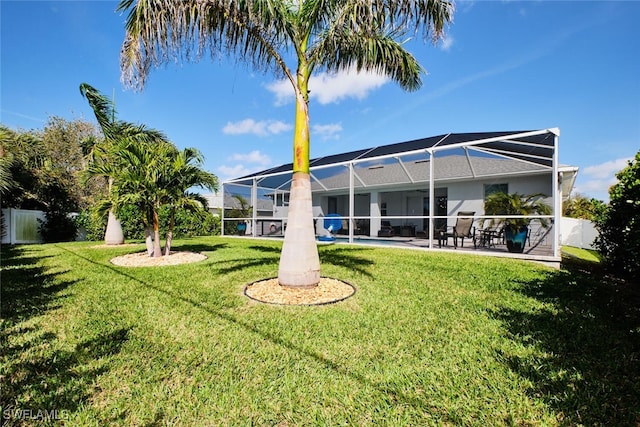 view of yard with glass enclosure, a patio, fence, and an outdoor pool