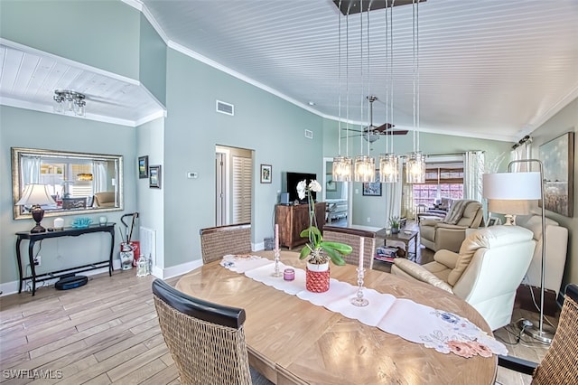 dining space featuring lofted ceiling, wood finished floors, visible vents, baseboards, and ornamental molding