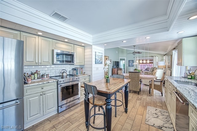 kitchen featuring stainless steel appliances, light wood-type flooring, a sink, and visible vents