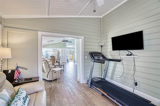 workout room with a ceiling fan, lofted ceiling, and light wood-type flooring