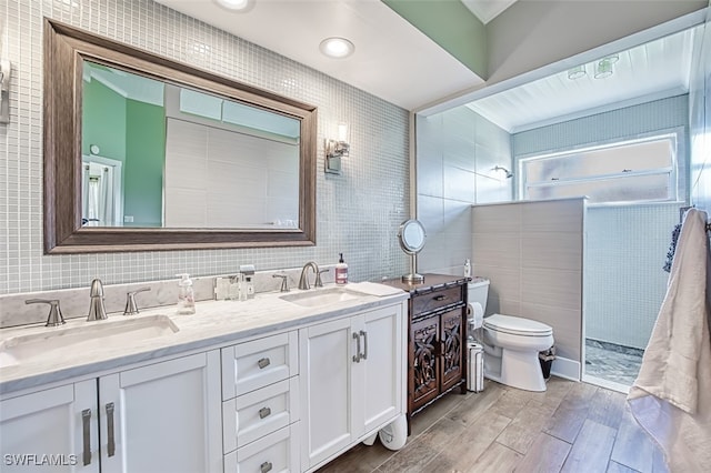 full bathroom with a sink, tile walls, toilet, and wood finished floors