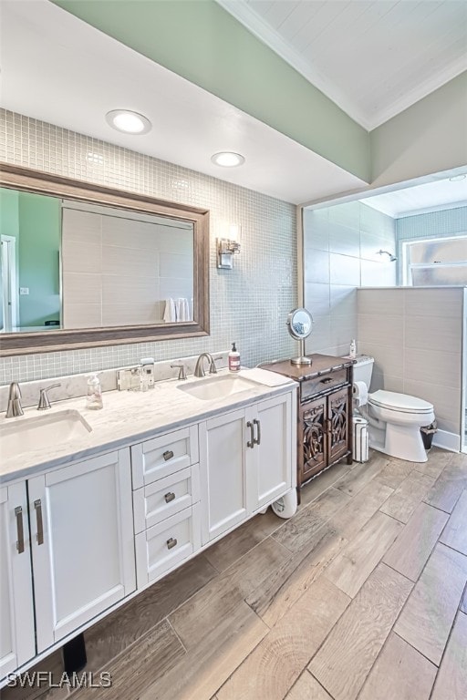 bathroom with toilet, tile walls, and a sink