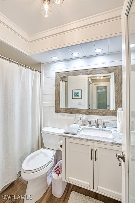 full bath with toilet, ornamental molding, wood finished floors, and vanity