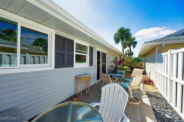 view of patio with outdoor dining area and fence