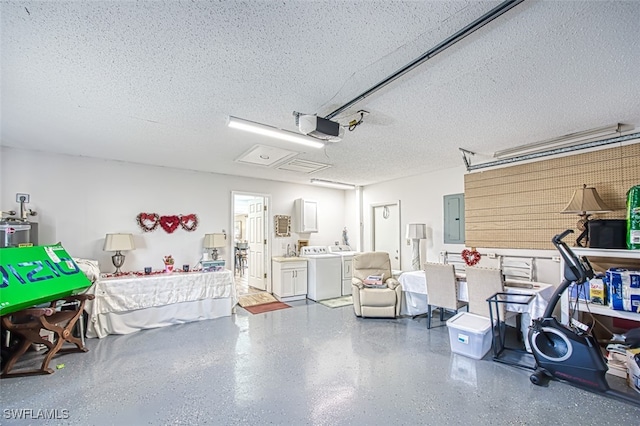 garage featuring electric panel, washer and dryer, and a garage door opener