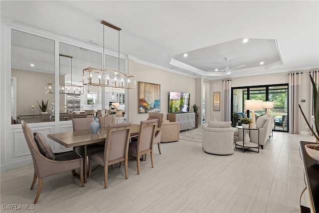 dining room featuring a tray ceiling, recessed lighting, crown molding, ceiling fan with notable chandelier, and light wood-type flooring