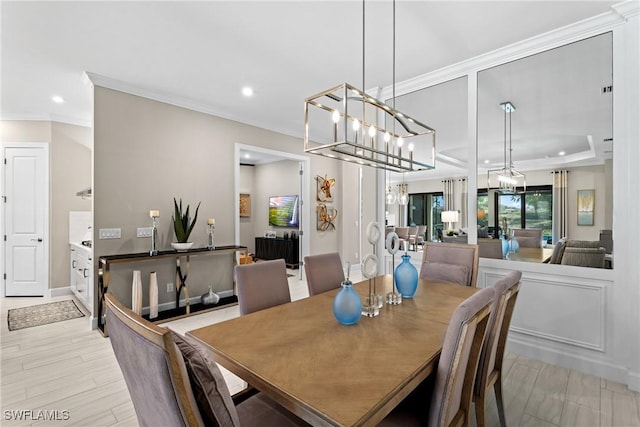 dining space with recessed lighting, light wood-style flooring, an inviting chandelier, and crown molding