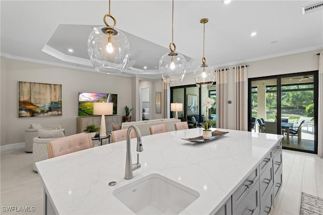 kitchen featuring a sink, visible vents, open floor plan, and ornamental molding