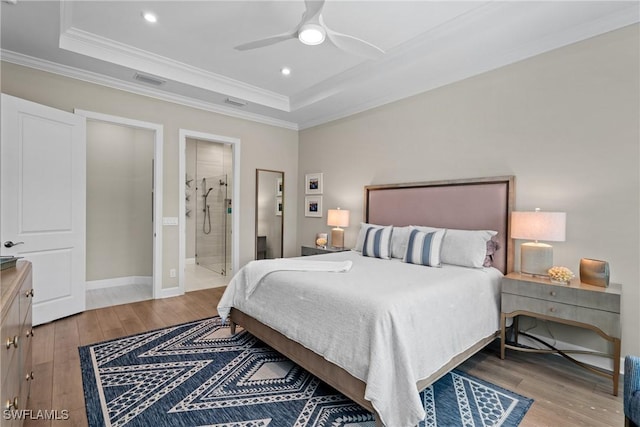 bedroom with a tray ceiling, crown molding, recessed lighting, and light wood-style floors