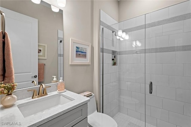 bathroom featuring vanity, toilet, and a stall shower