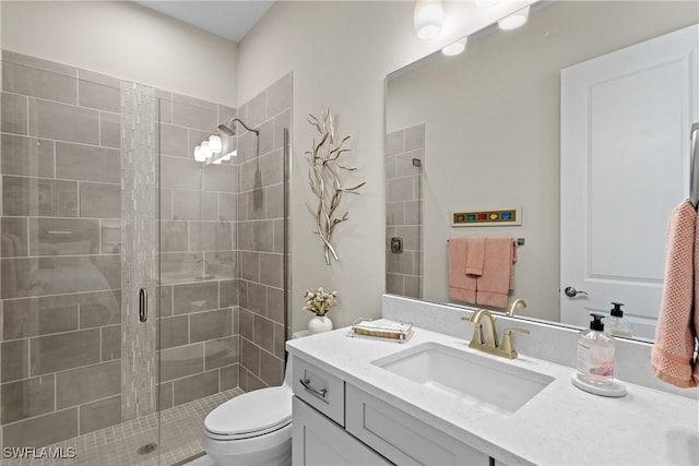 full bathroom featuring vanity, toilet, and a shower stall