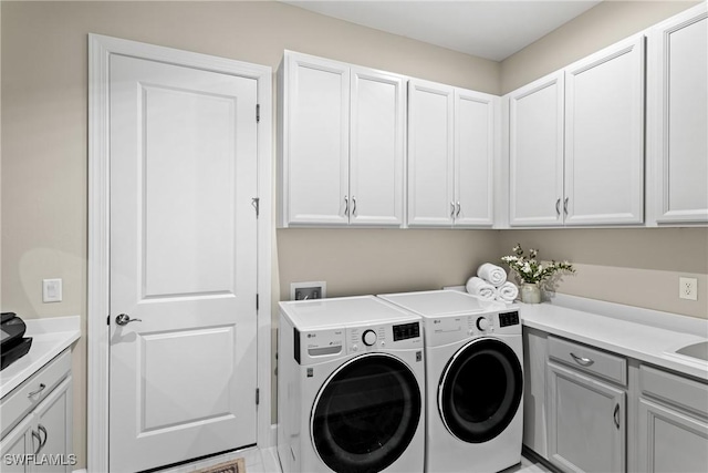 clothes washing area featuring cabinet space and washing machine and dryer