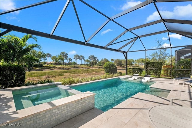 pool with glass enclosure, an in ground hot tub, and a patio area