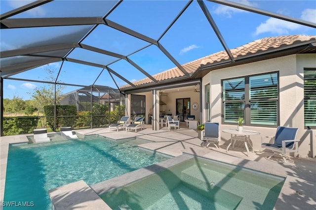 view of swimming pool with a lanai, ceiling fan, a pool with connected hot tub, and a patio area