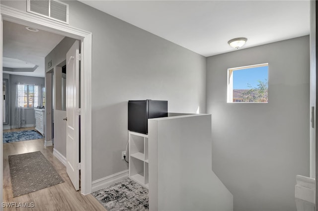 office area with light wood finished floors, baseboards, and visible vents