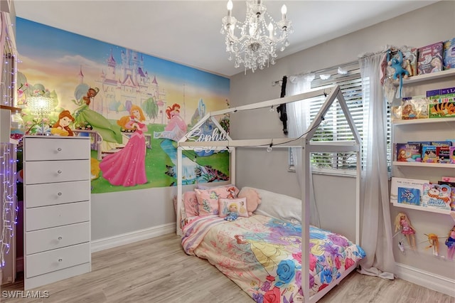 bedroom featuring baseboards, light wood finished floors, and a notable chandelier