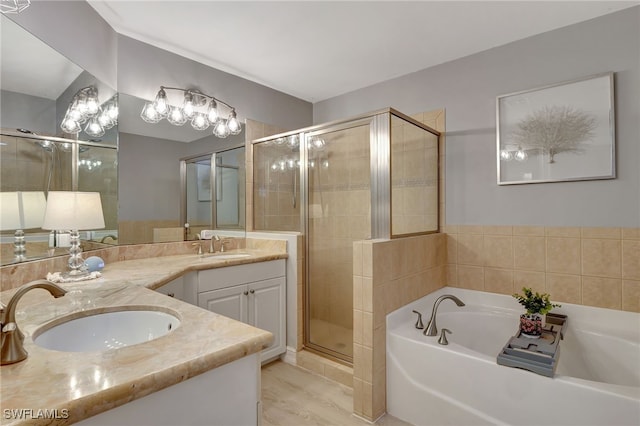 bathroom featuring a stall shower, a garden tub, a sink, and double vanity