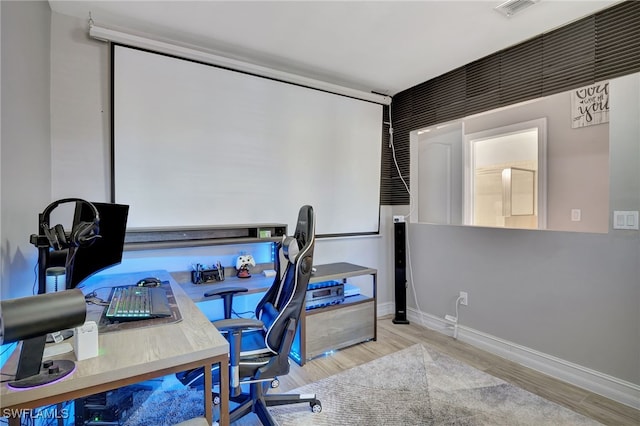 home office with visible vents, light wood-style flooring, and baseboards