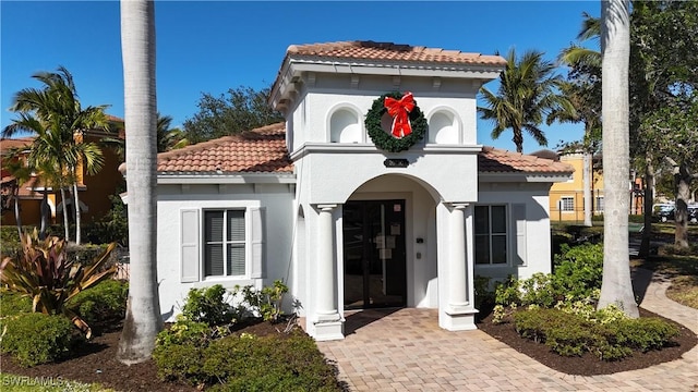 mediterranean / spanish house with a tiled roof and stucco siding