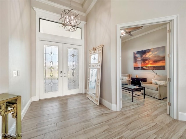 entrance foyer featuring ornamental molding, french doors, and an inviting chandelier