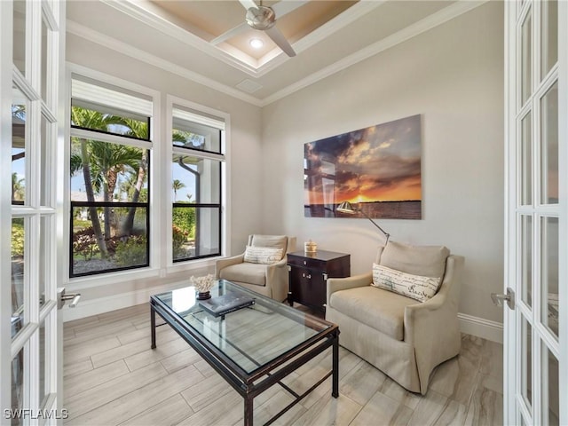 living area featuring baseboards, ornamental molding, a ceiling fan, and french doors