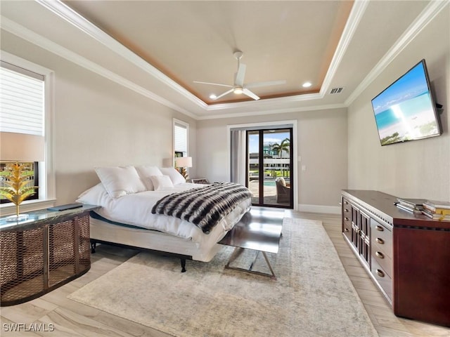 bedroom with light wood-type flooring, access to outside, a raised ceiling, and visible vents