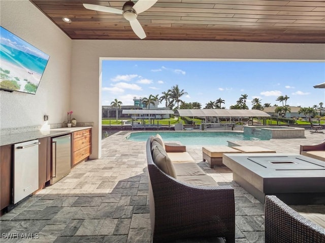 view of swimming pool featuring a ceiling fan, a pool with connected hot tub, a patio, and area for grilling