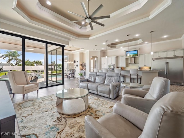 living room with a tray ceiling and crown molding