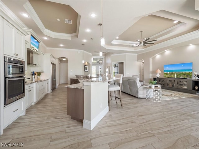 kitchen with white cabinetry, a raised ceiling, and open floor plan