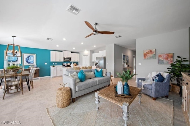 living room with recessed lighting, visible vents, light tile patterned flooring, and ceiling fan with notable chandelier